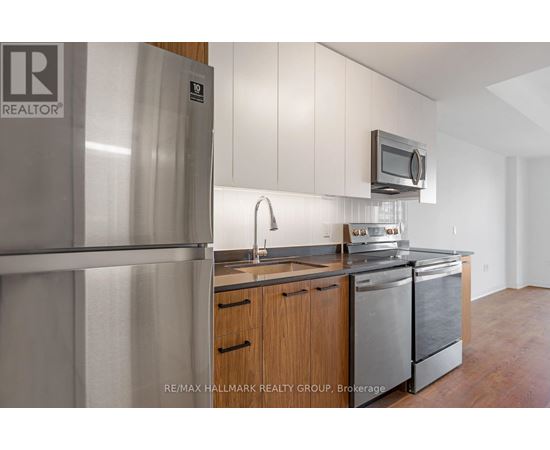 A kitchen with a refrigerator and a microwave.