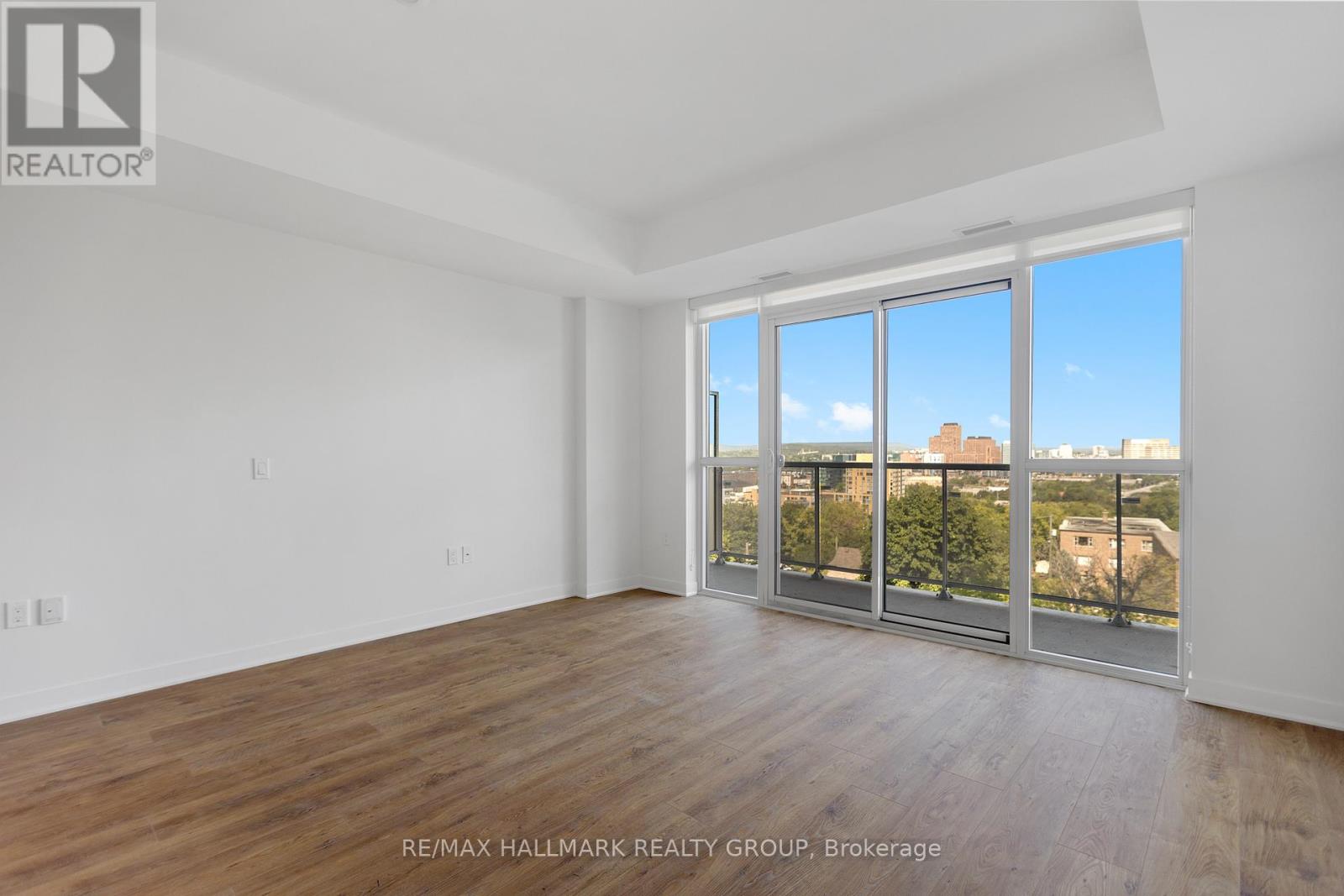 A spacious room with a view of the city through large windows.