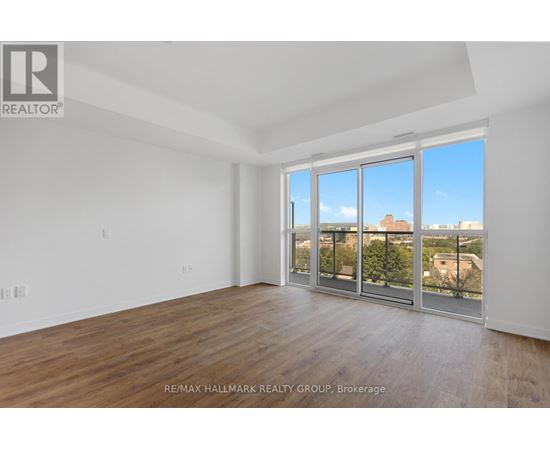 A spacious room with a view of the city through large windows.