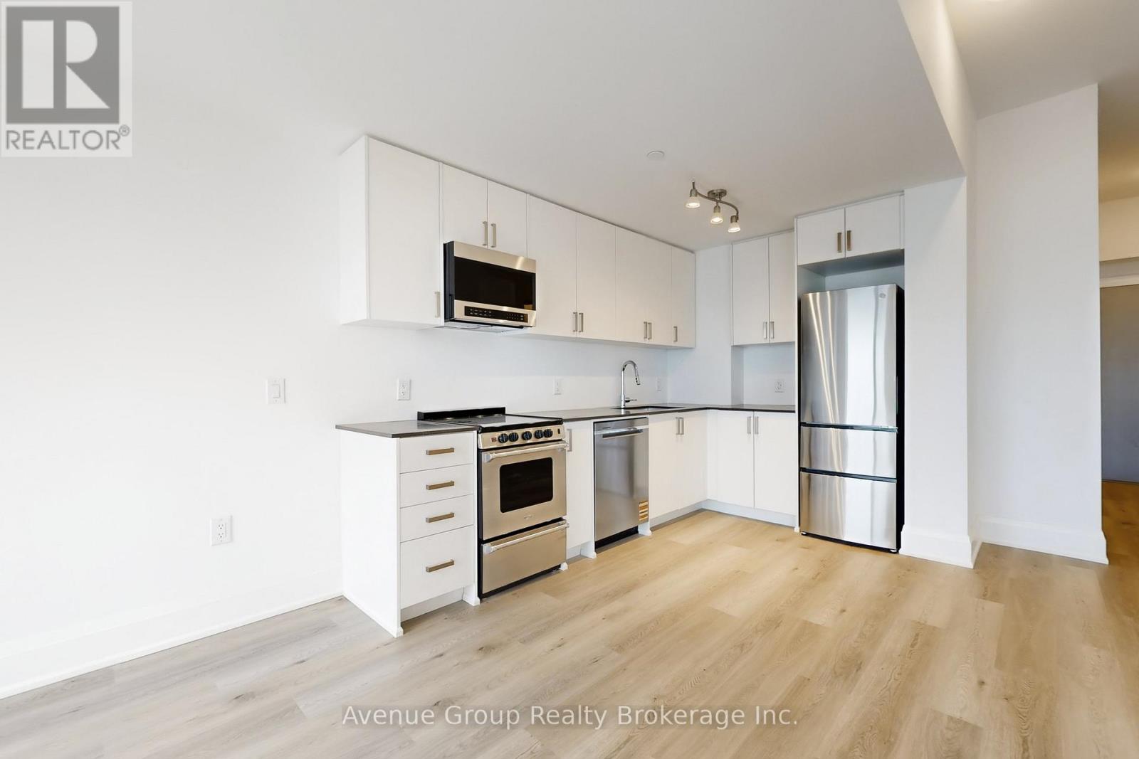 A modern kitchen with white cabinets and stainless steel appliances.