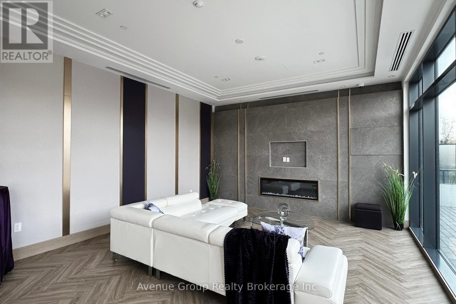 A modern bedroom with a large bed and a fireplace.