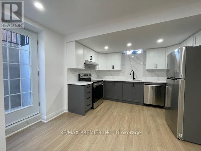 A kitchen with white cabinets and a refrigerator.