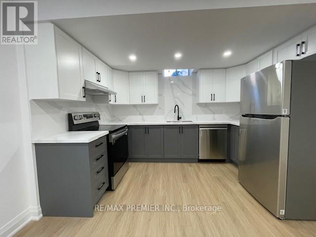 A kitchen with white cabinets and a stainless steel refrigerator.