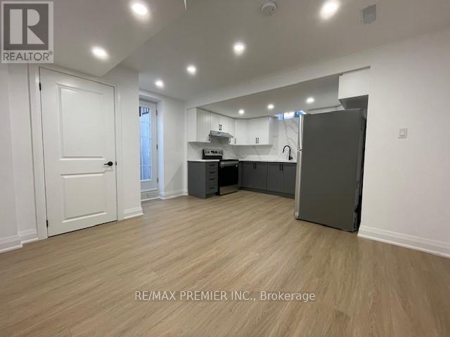 A spacious room with a kitchenette and a refrigerator.