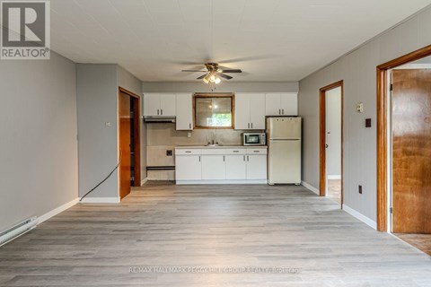 A kitchen with white cabinets and a microwave above the stove.