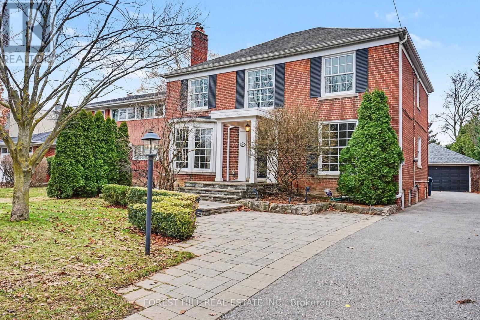 A brick house with a front yard and a driveway.