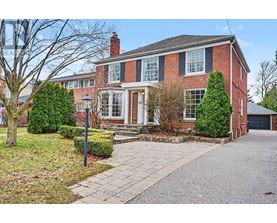 A brick house with a front yard and a driveway.
