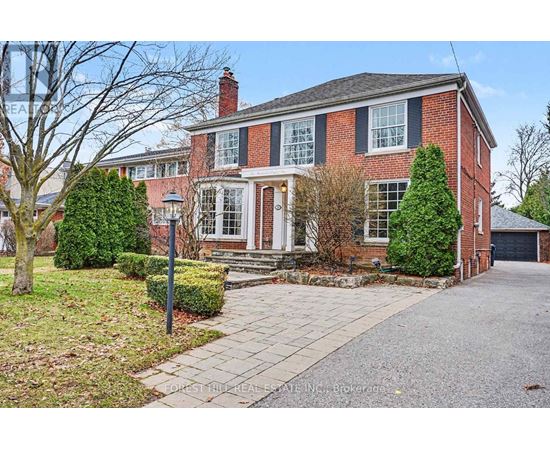 A brick house with a front yard and a driveway.