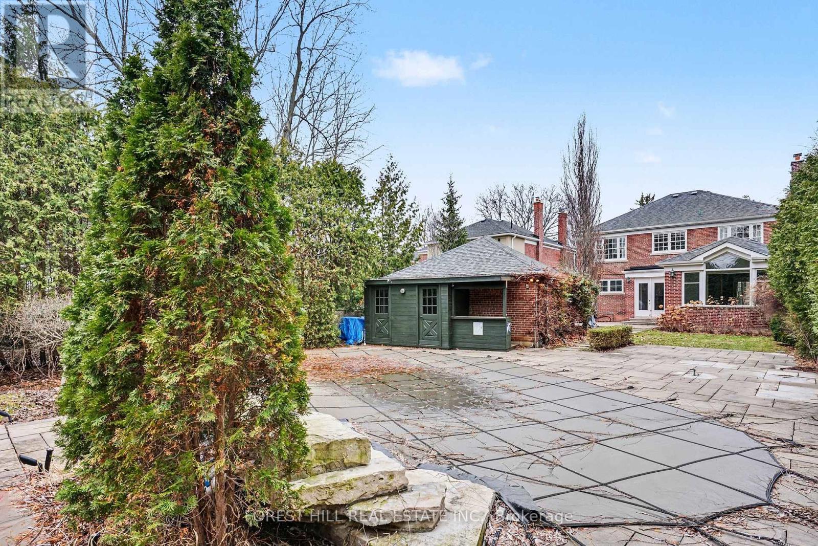 A large backyard with a pool and a house in the background.