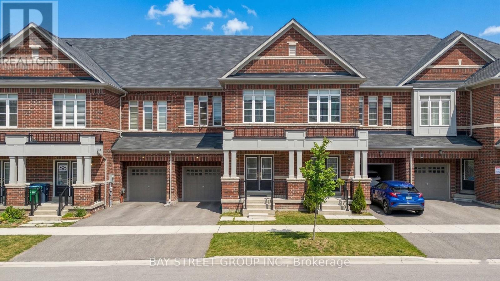 A two-story brick house with a garage is for sale.
