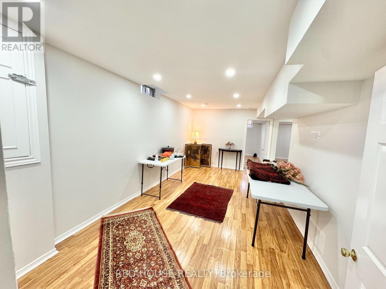 A room with a rug on the floor and a table with a lamp on it.