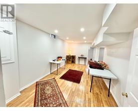 A room with a rug on the floor and a table with a lamp on it.