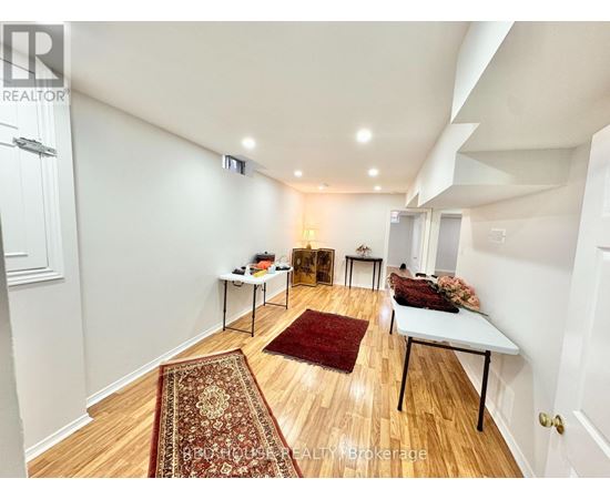 A room with a rug on the floor and a table with a lamp on it.