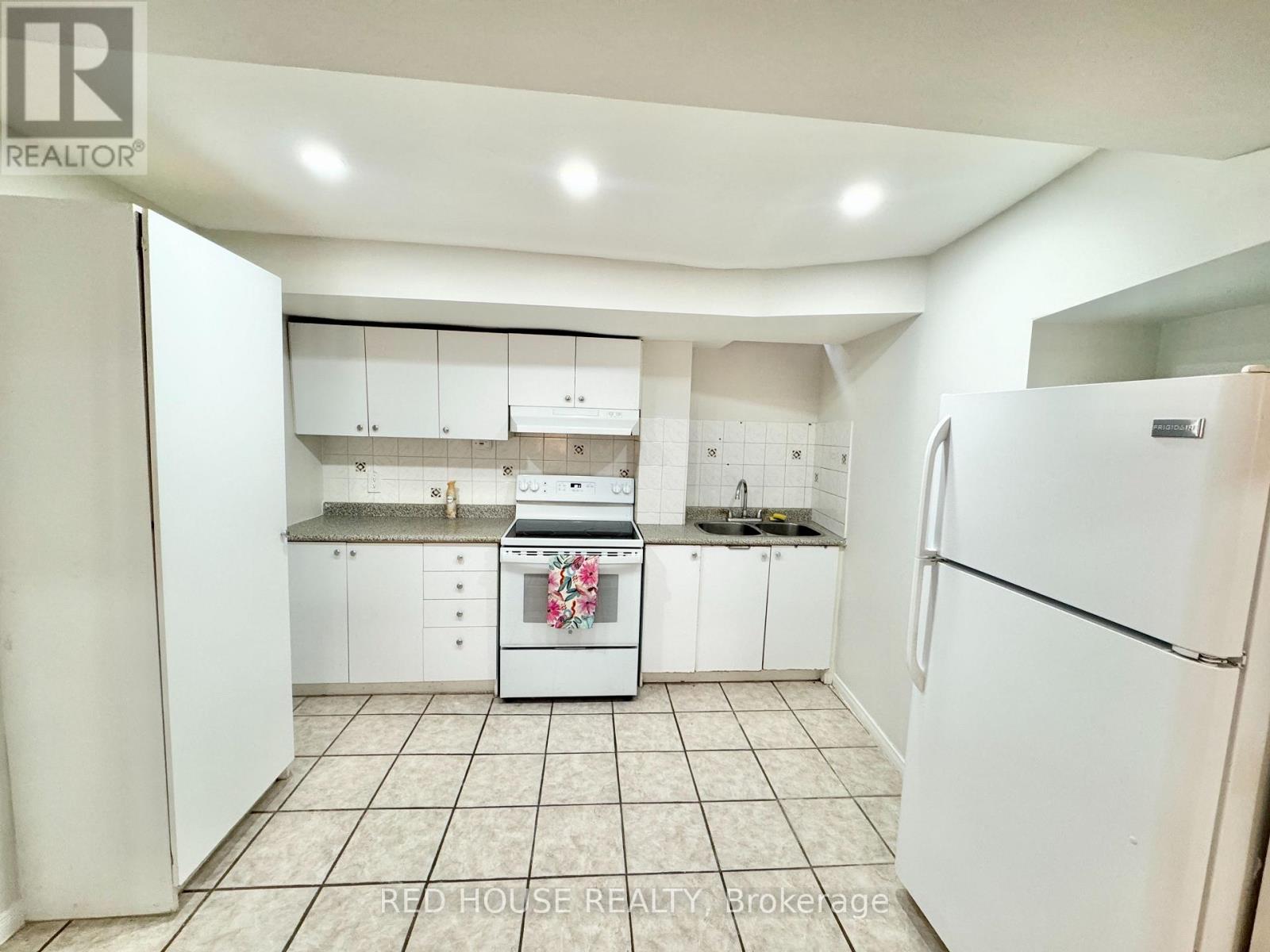 A kitchen with white appliances and cabinets.