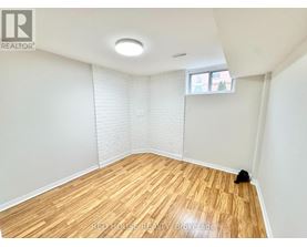 A room with wooden flooring and a window with blinds.