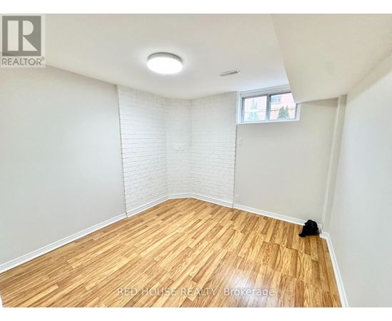 A room with wooden flooring and a window with blinds.
