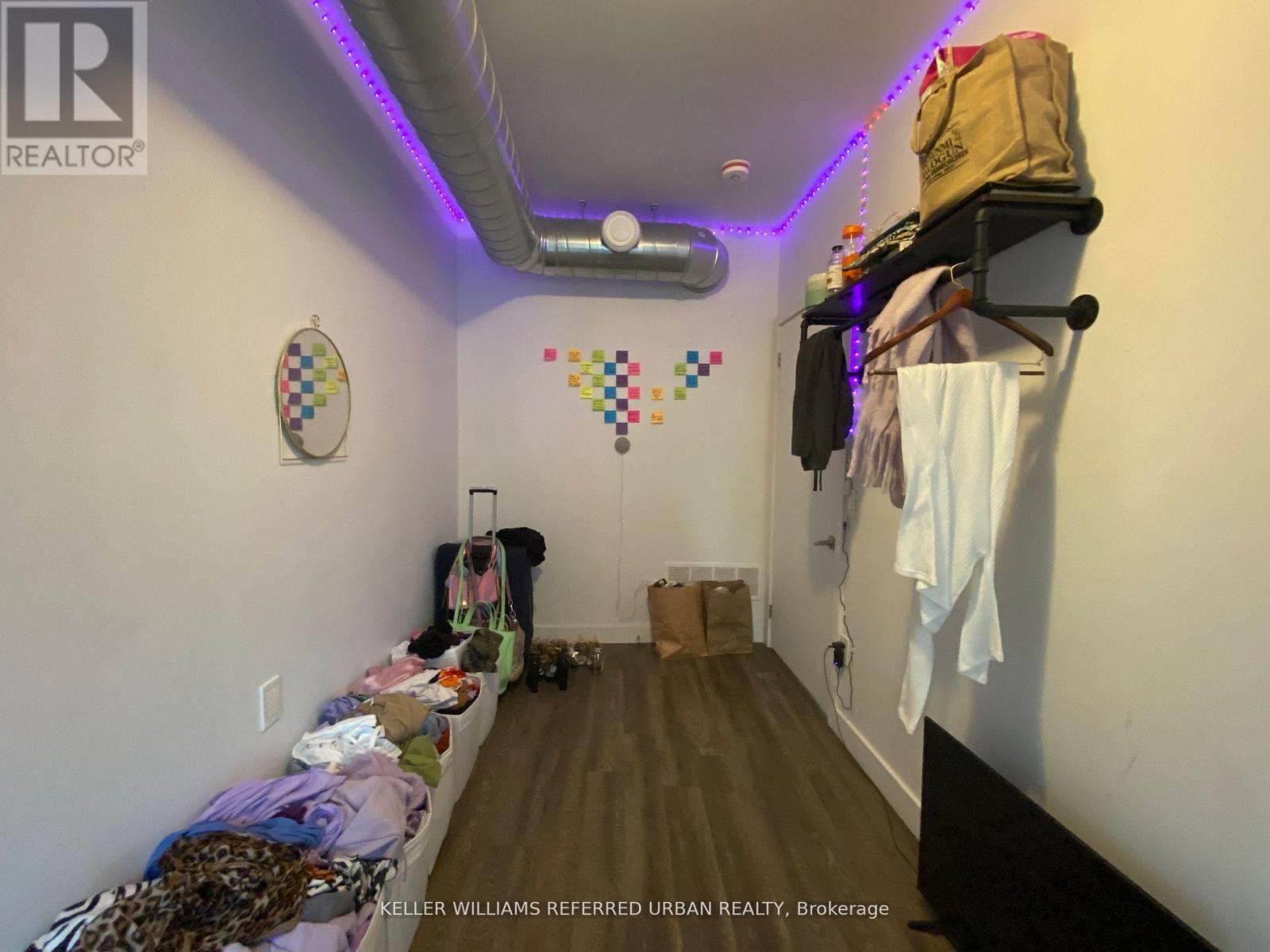A room with a lot of clutter and a sign that says "KELLER WILLIAMS REFERRED URBAN REALTY Brokerage".