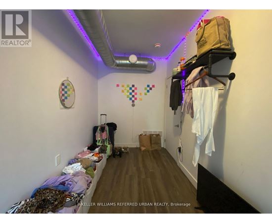 A room with a lot of clutter and a sign that says "KELLER WILLIAMS REFERRED URBAN REALTY Brokerage".