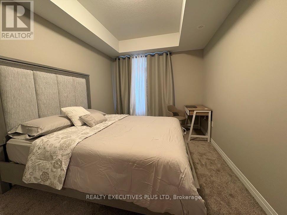 A bedroom with a large bed and a window with curtains.