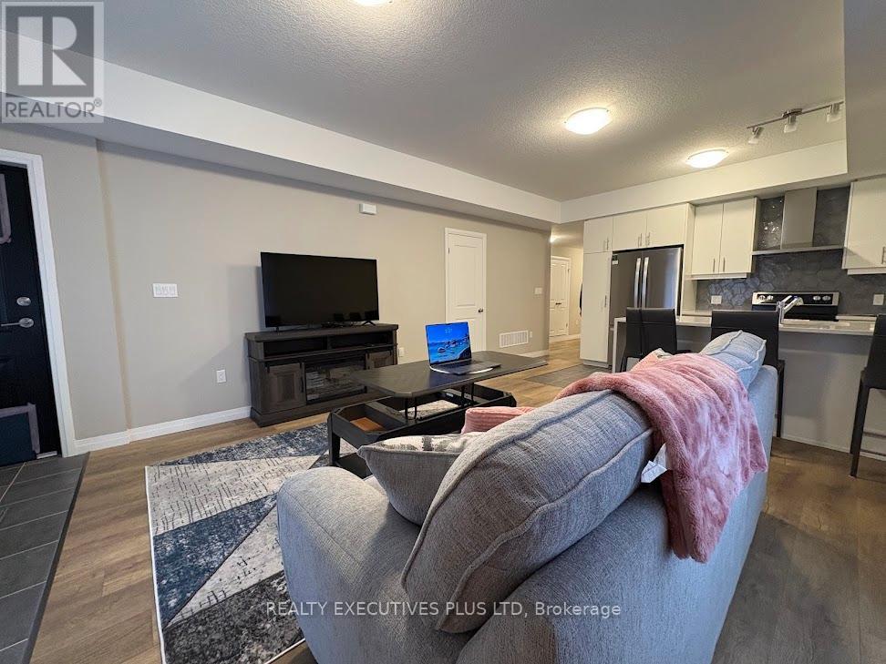 A living room with a grey couch and a black television.