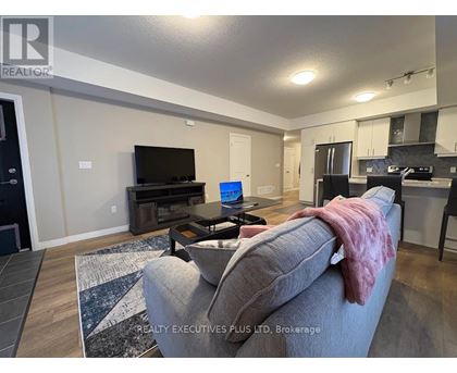 A living room with a grey couch and a black television.