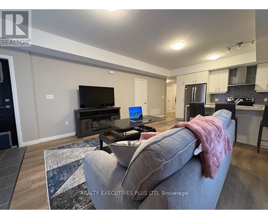 A living room with a grey couch and a black television.