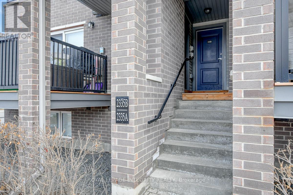 A brick building with a blue door and a balcony with a black railing.