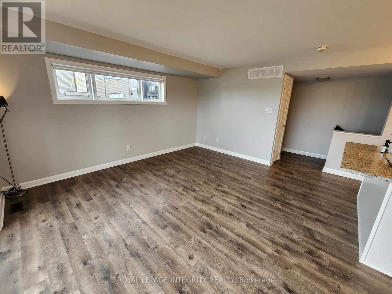 A room with wooden flooring and a window.