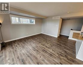 A room with wooden flooring and a window.