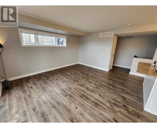 A room with wooden flooring and a window.