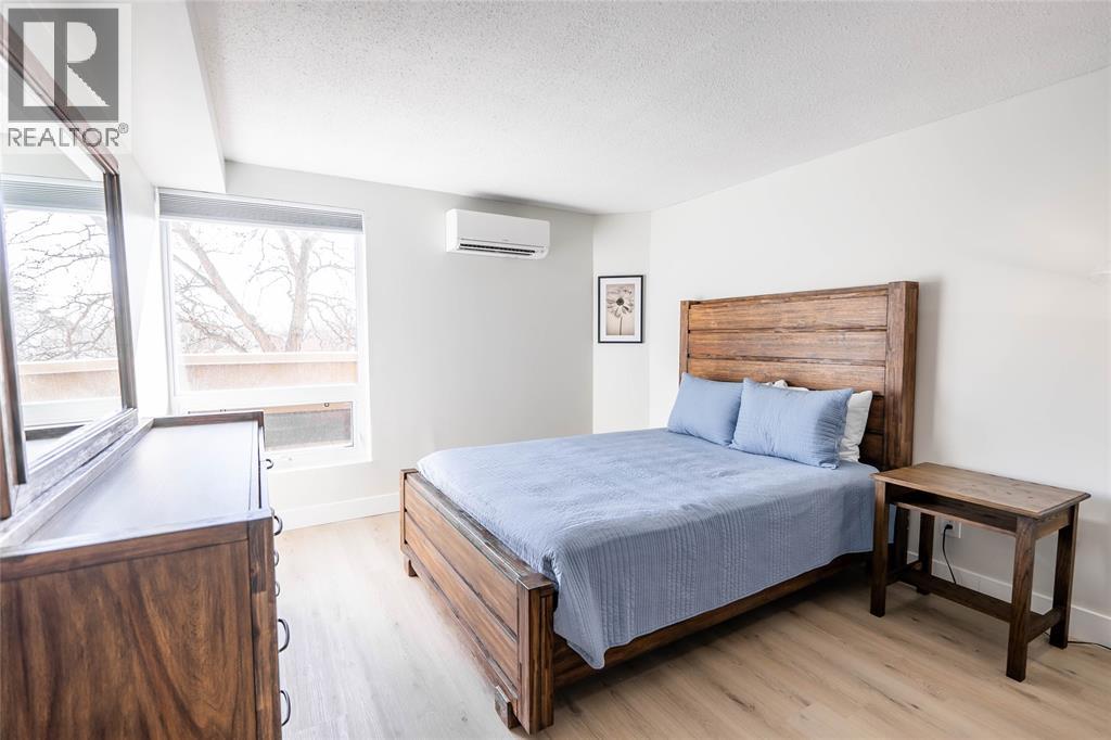 A bedroom with a bed, nightstand, and window.