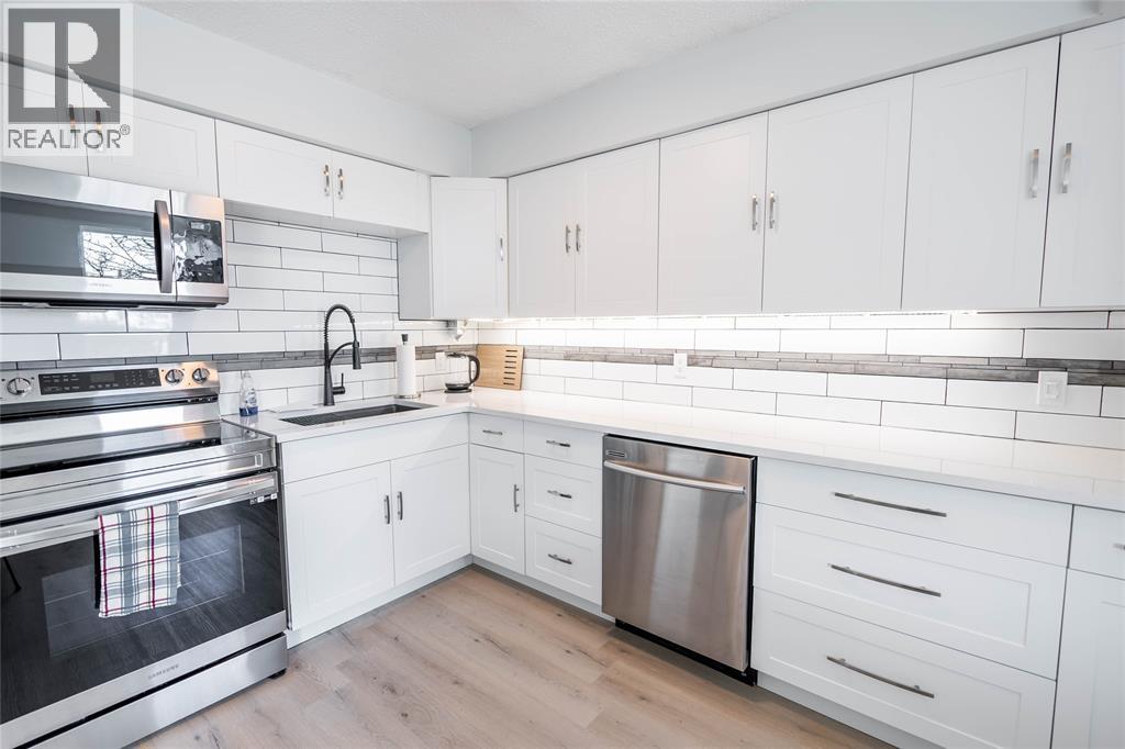 A modern kitchen with white cabinets and a stainless steel dishwasher.