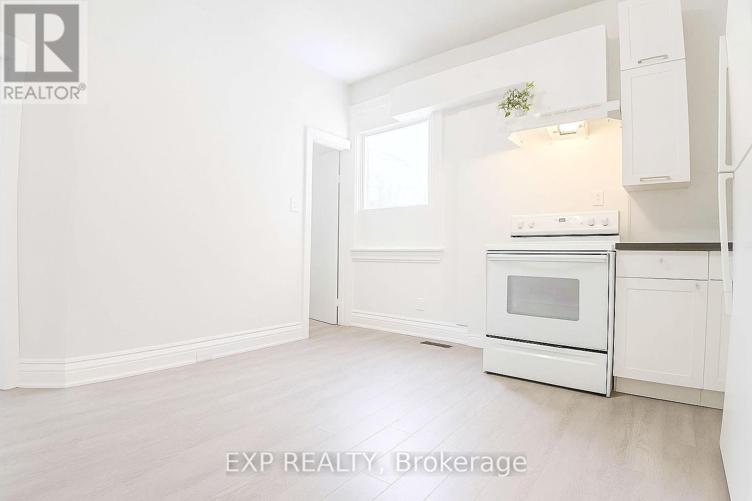 A white kitchen with EXP REALTY Brokerage written on the bottom.