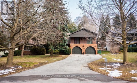 A house with a brick facade and a driveway in front.