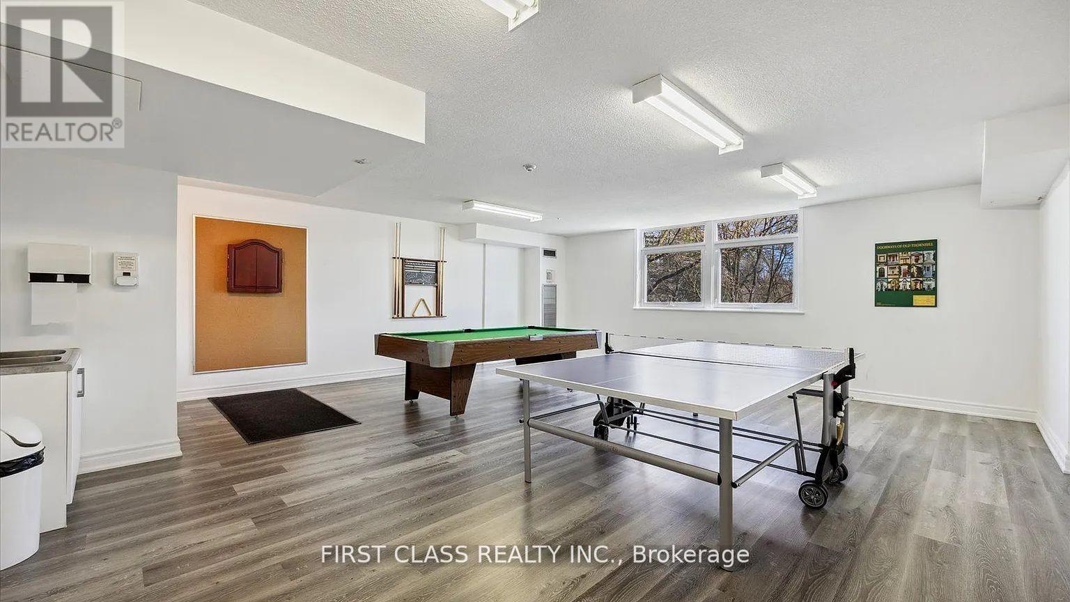 A room with a pool table and a picture of a house on the wall.