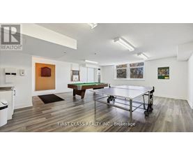 A room with a pool table and a picture of a house on the wall.