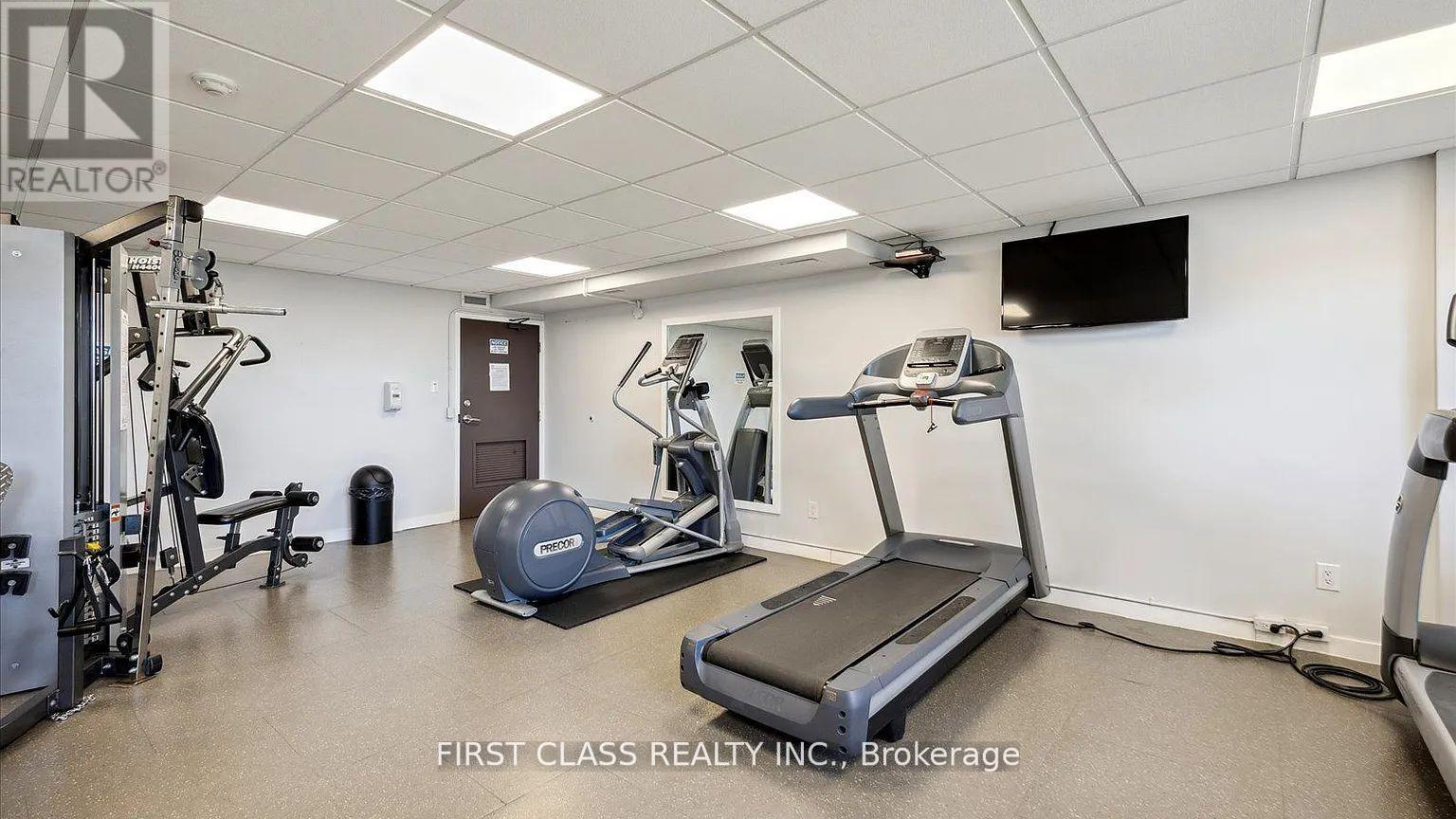 A gym room with a treadmill, weights and exercise equipment.