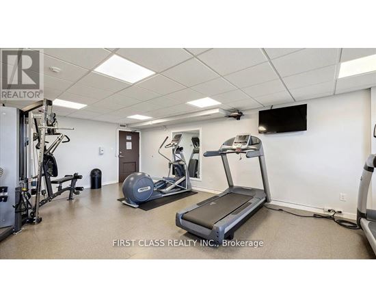 A gym room with a treadmill, weights and exercise equipment.