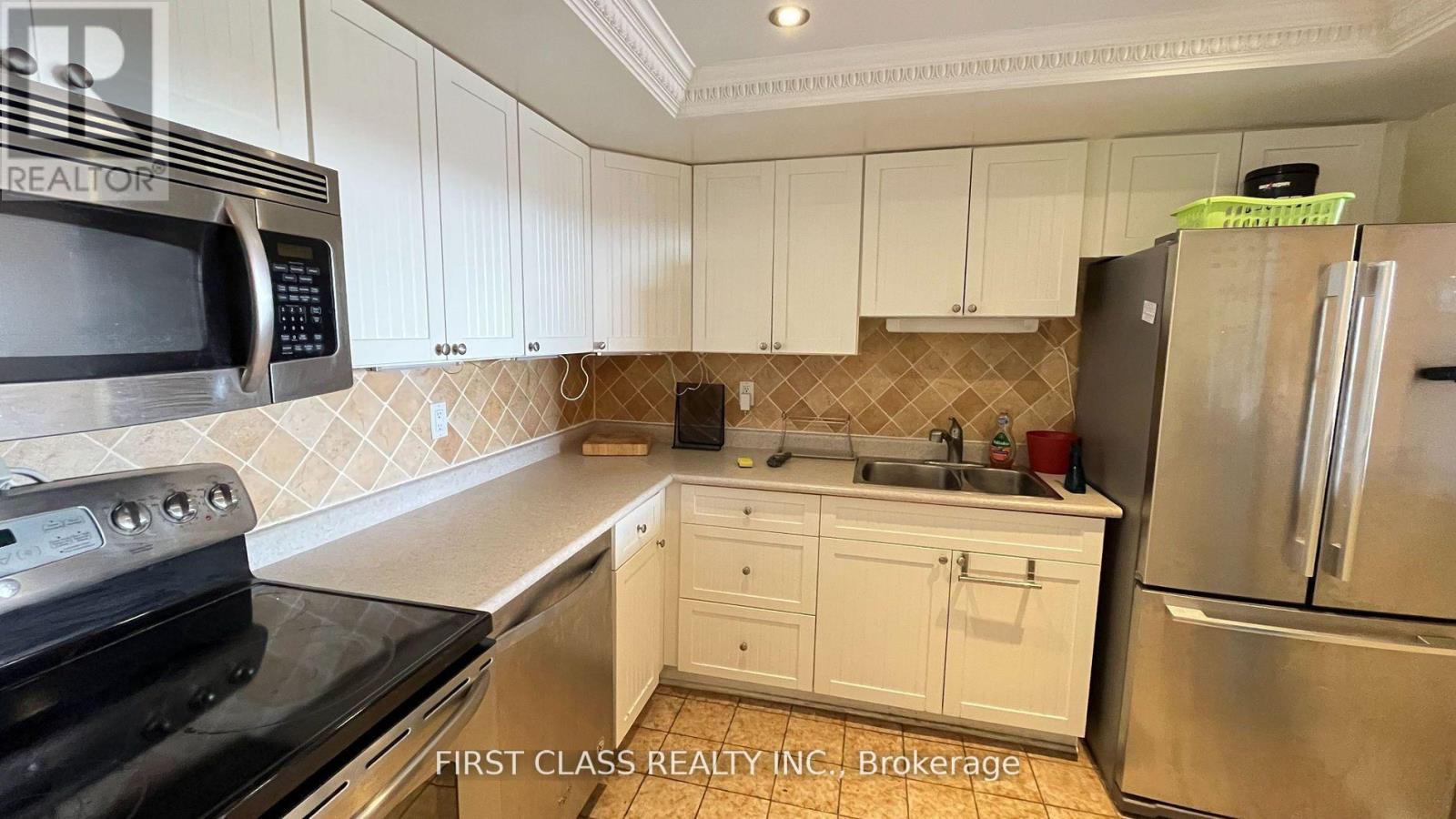 A kitchen with white cabinets and a black stove top oven.