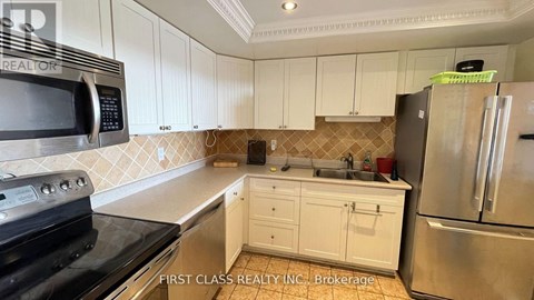 A kitchen with white cabinets and a black stove top oven.