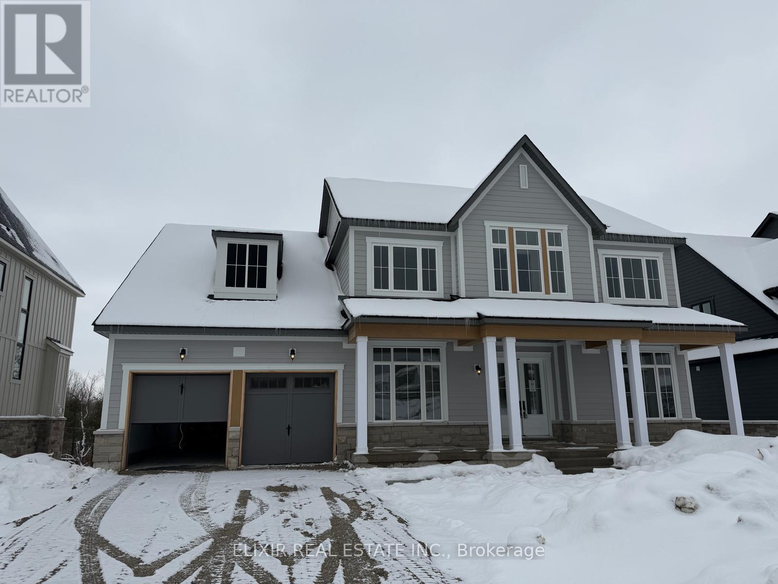 A house with a snow-covered roof and garage doors.