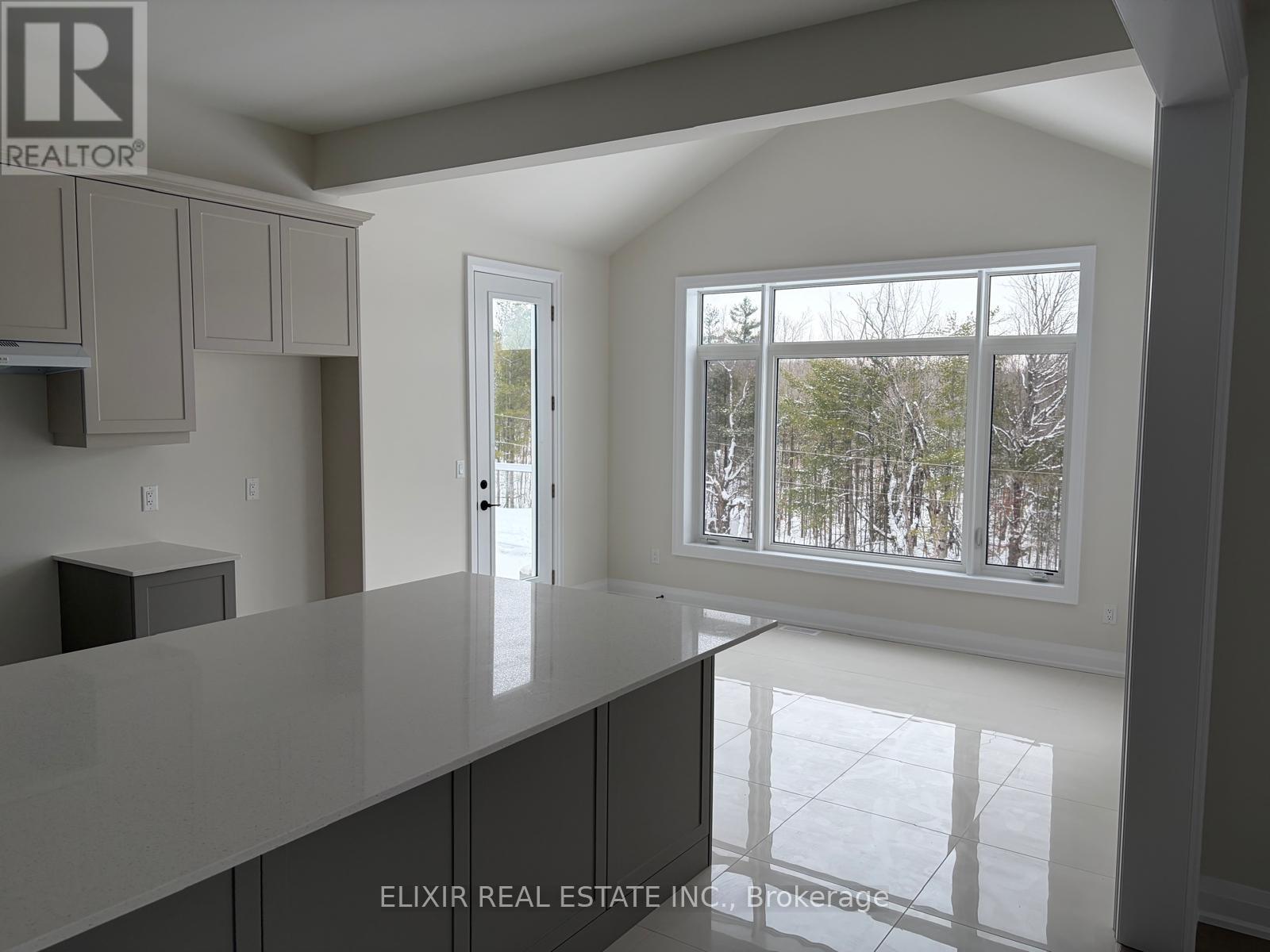 A real estate company logo is displayed on a wall above a kitchen counter.