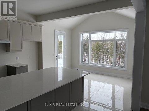 A real estate company logo is displayed on a wall above a kitchen counter.