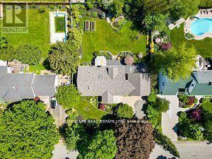 A bird's eye view of a residential area with a swimming pool and green lawns.
