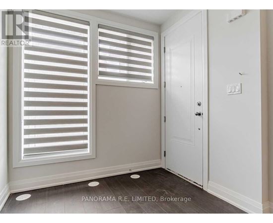 A room with a door and a window with shutters.