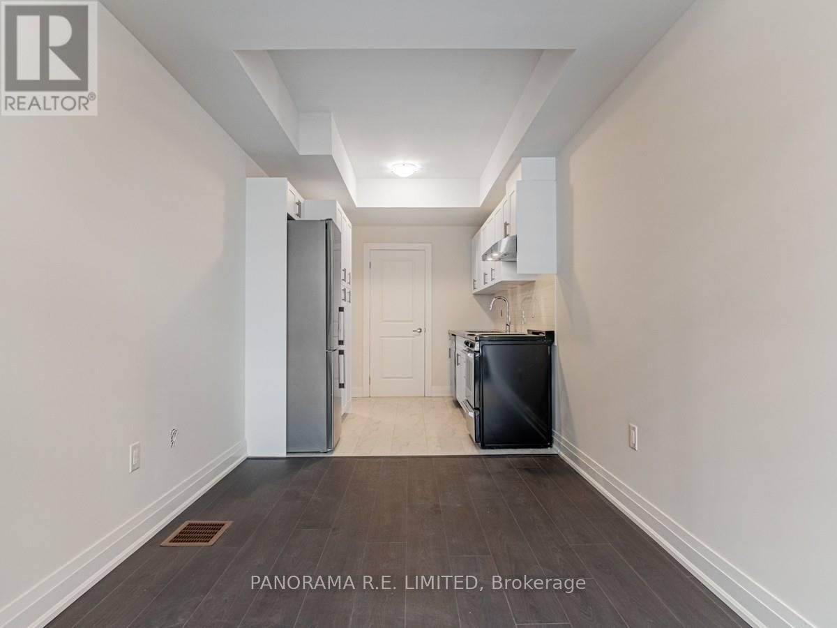 A spacious hallway with a refrigerator and a cabinet on the wall.