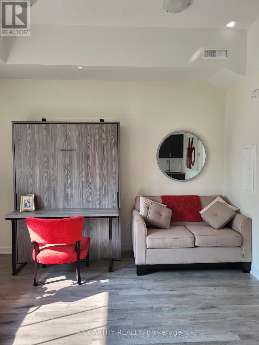 A living room with a red chair and a grey couch.