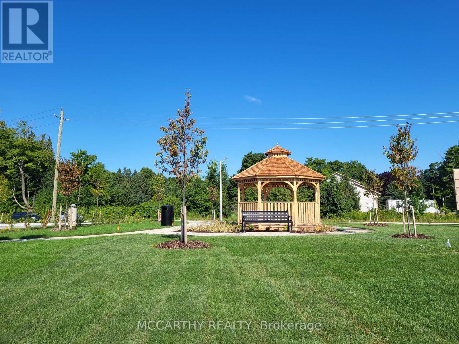 A gazebo sits in the middle of a grassy field.