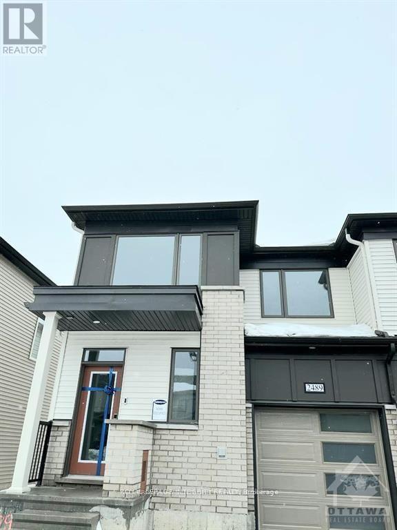 A modern house with a grey facade and a blue door.