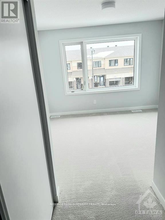 A room with a window showing a view of a street with buildings.